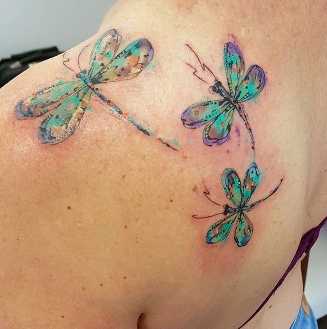 Green and purple sequential dragonfly tattoo on body for women