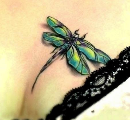 Green colored dragonfly tattoo on women chest