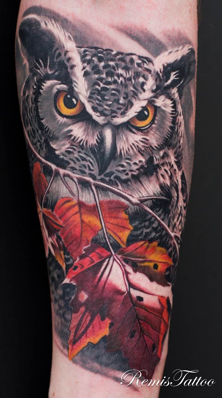 Grey and white realistic owl with orange color leaves tattoo on men arm by Remis Tattoo