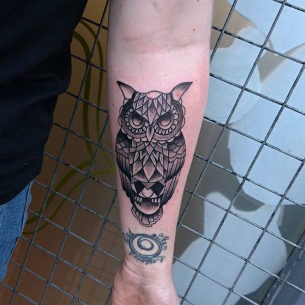 Grey ink geometric owl tattoo on man forearm
