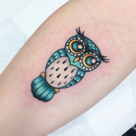 Small green traditional baby owl tattoo on forearm