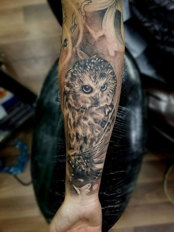 Wonderful realistic owl tattoo on male inner forearm