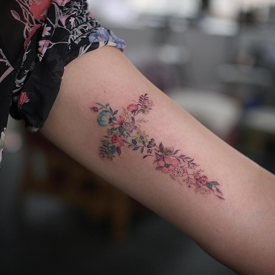 Astonishing floral cross tattoo on girl arm
