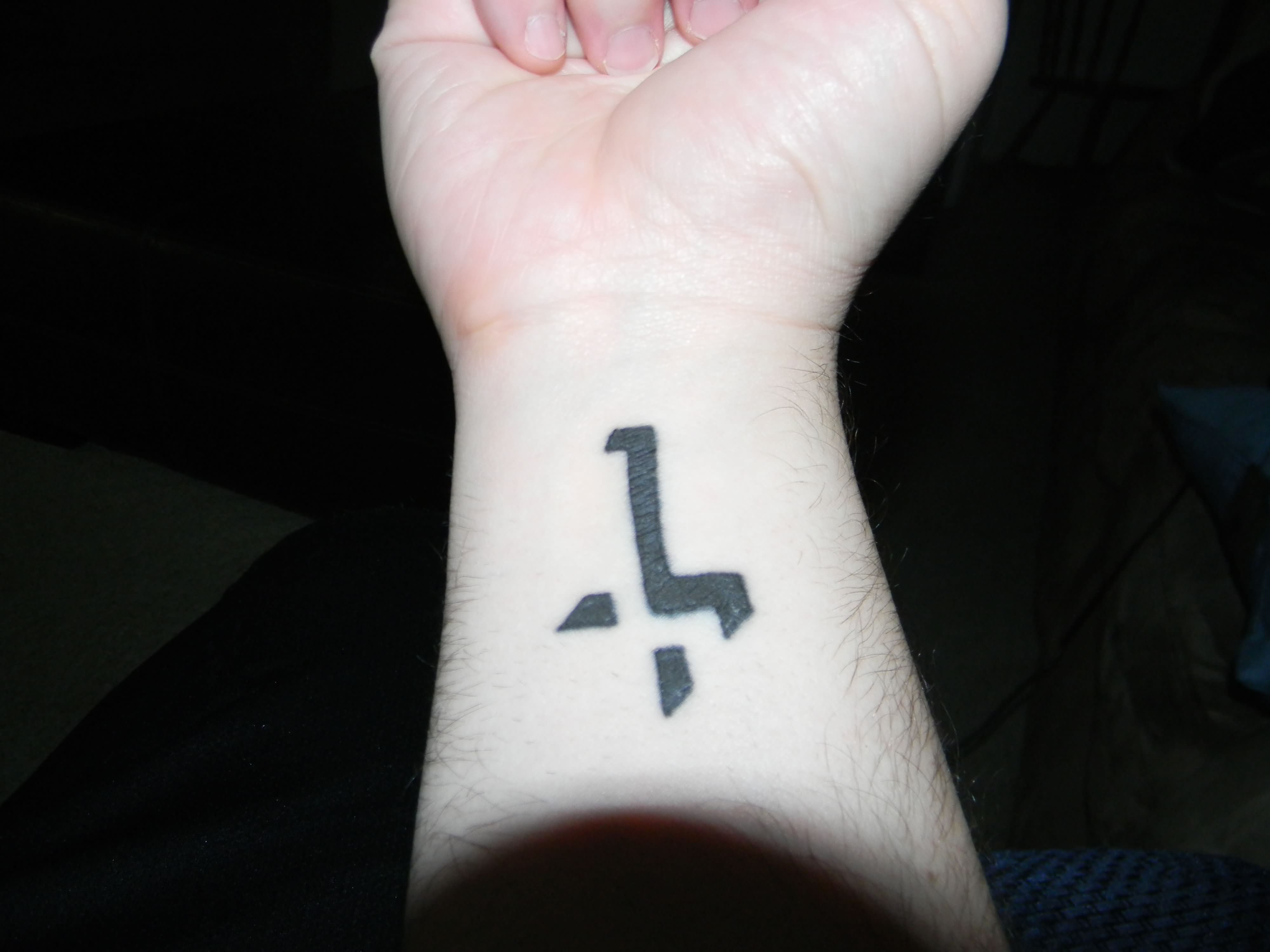 Black 3d cross tattoo on inner arm