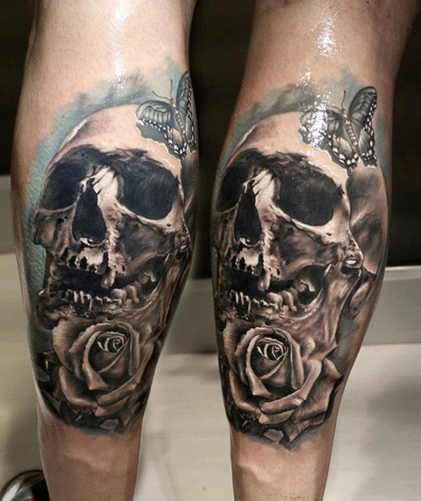 Black and blue shaded skull and rose with butterfly tattoo on body