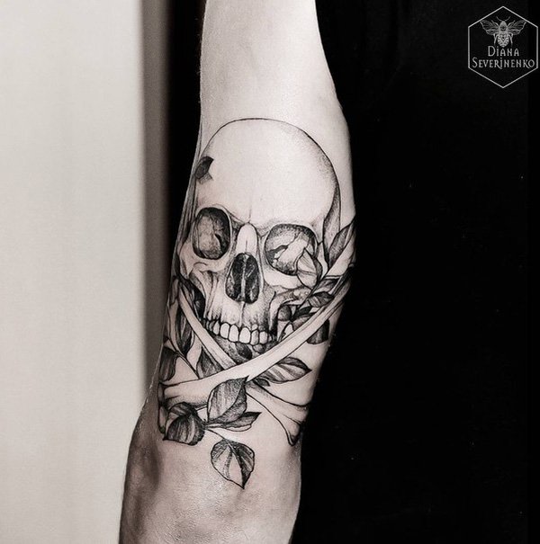 Black and grey death’s head skull tattoo on upper sleeve