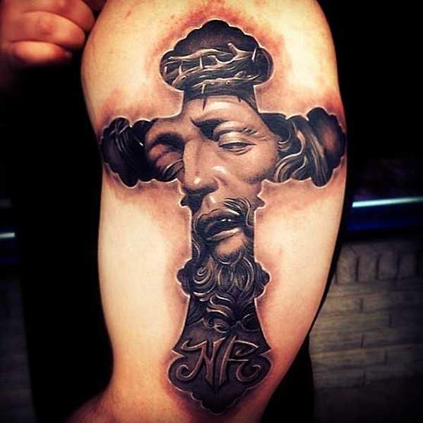 Black and grey shaded Jesus picture in cross tattoo on upper arm for men