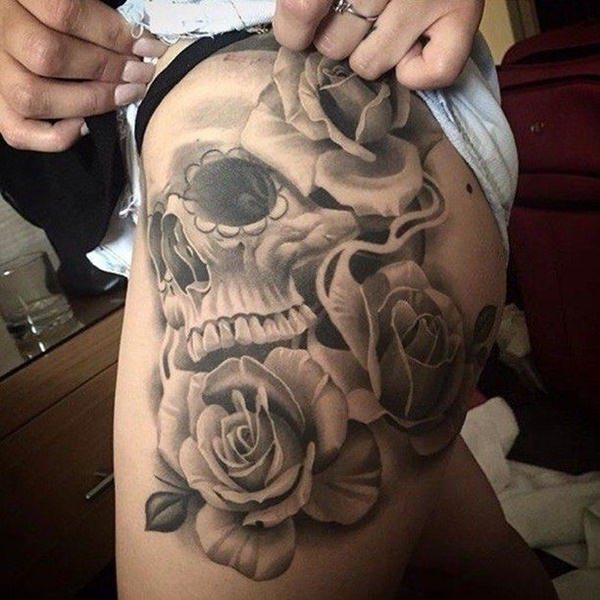 Black and grey shaded skull and roses tattoo on left upper leg for women