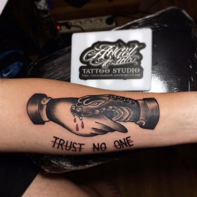 Black and grey shaded snake hand shake trust no one tattoo on forearm