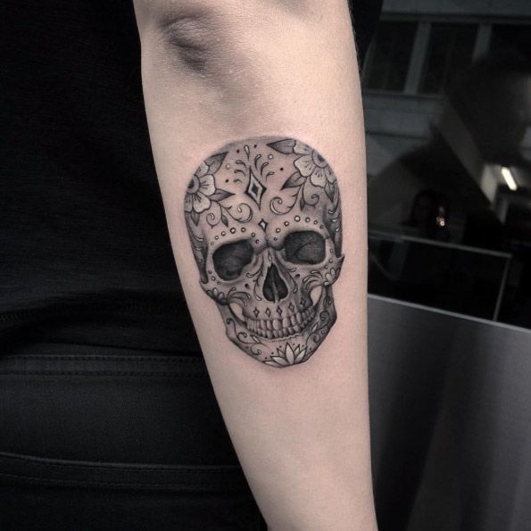 Black and grey shaded sugar skull tattoo on lower arm for women