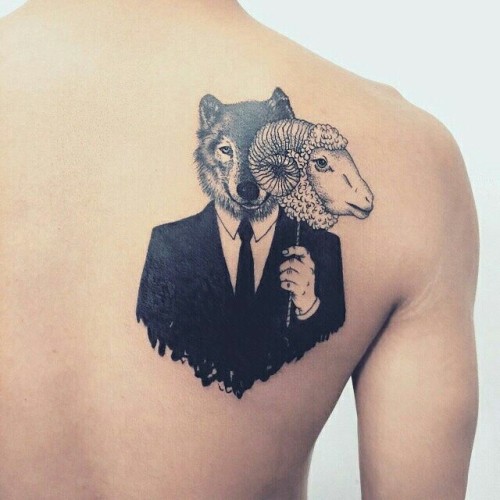 Black and grey shaded wolf and sheep trust no one tattoo on upper right back