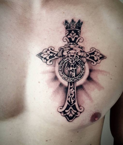 Black antique design cross with lion and crown tattoo on left chest