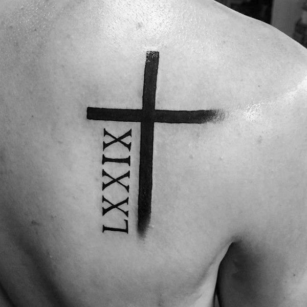 Black cross tattoo on upper right back for men