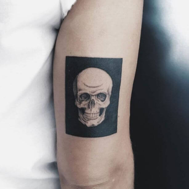 Black skull tattoo on upper arm