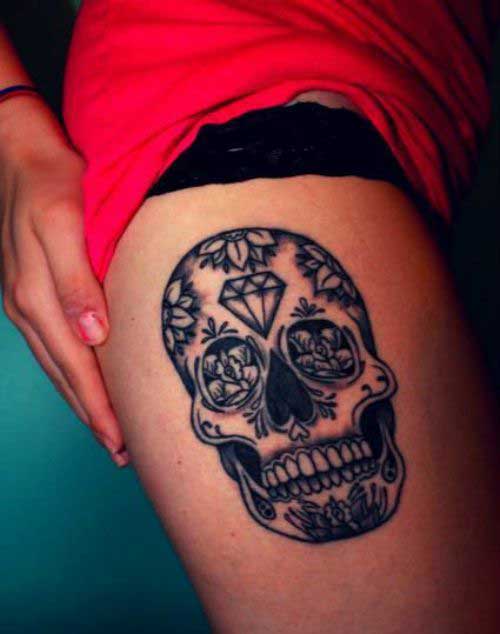 Black sugar skull tattoo on right thigh for women