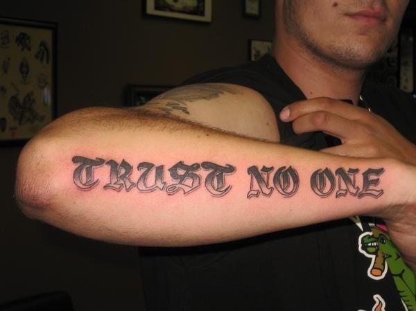 Black trust no one tattoo on forearm