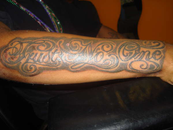 Black trust no one tattoo on full forearm