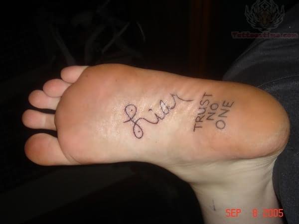 Black trust no one tattoo on sole of foot