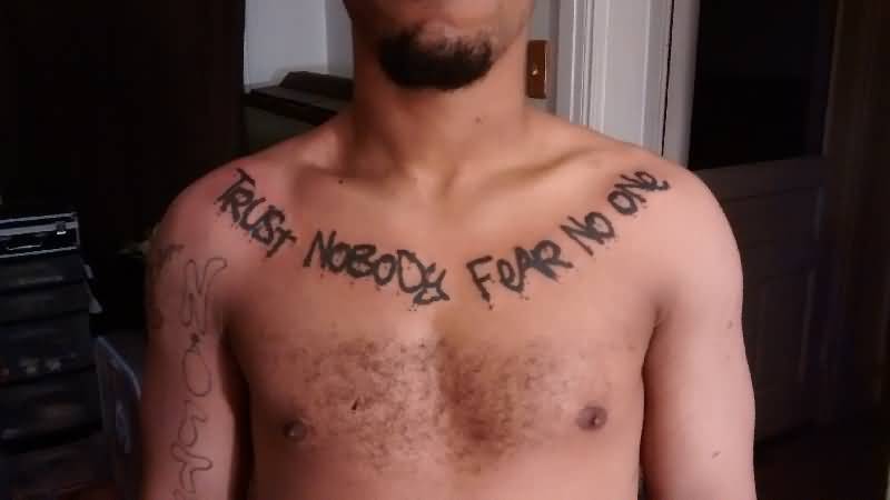 Black trust no one tattoo on upper chest for men