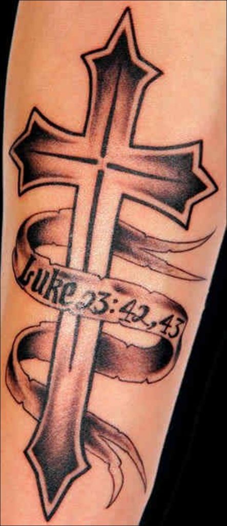 Grey and black shaded cross with date tattoo on arm