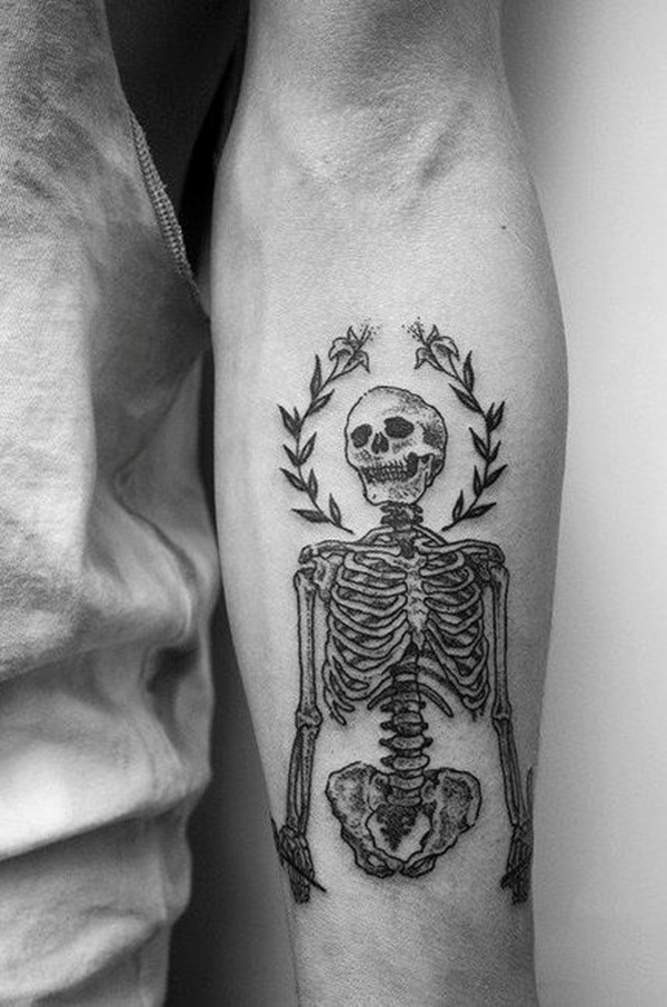 Grey full skeleton skull tattoo on inner lower arm