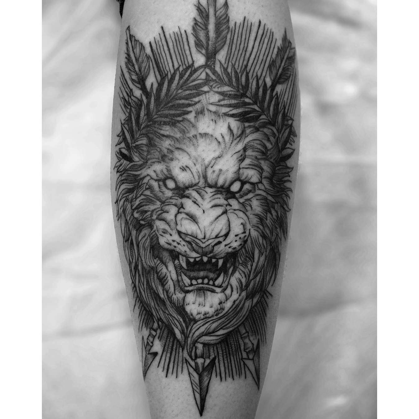 Grey roaring lion tattoo on sleeve