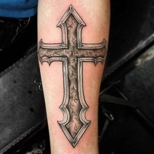 Grey shaded cross tattoo on arm