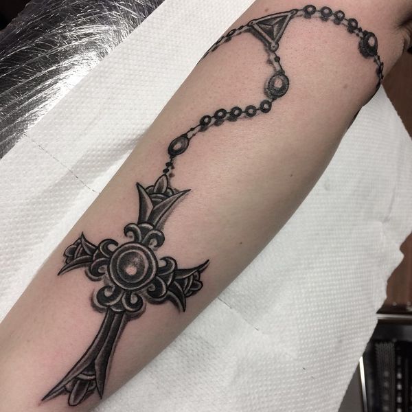 Grey shaded Gothic cross tattoo on arm for women