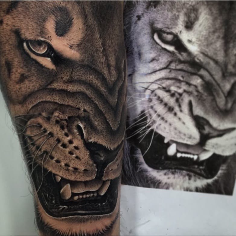 Grey shaded lion tattoo on arm
