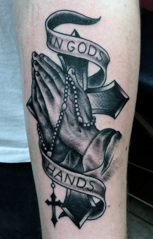 Grey shaded prayer hands with rosary and cross tattoo on leg