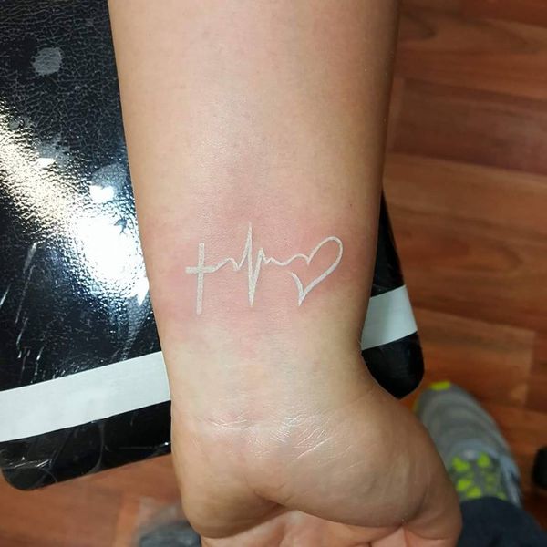 White Ink Cross With Heart Beat and Heart Tattoo On Girl's Wrist