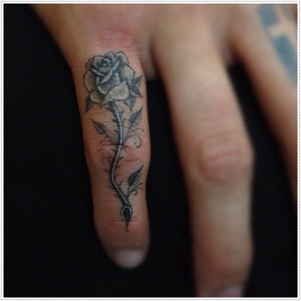 Black and grey shaded rose tattoo on small finger