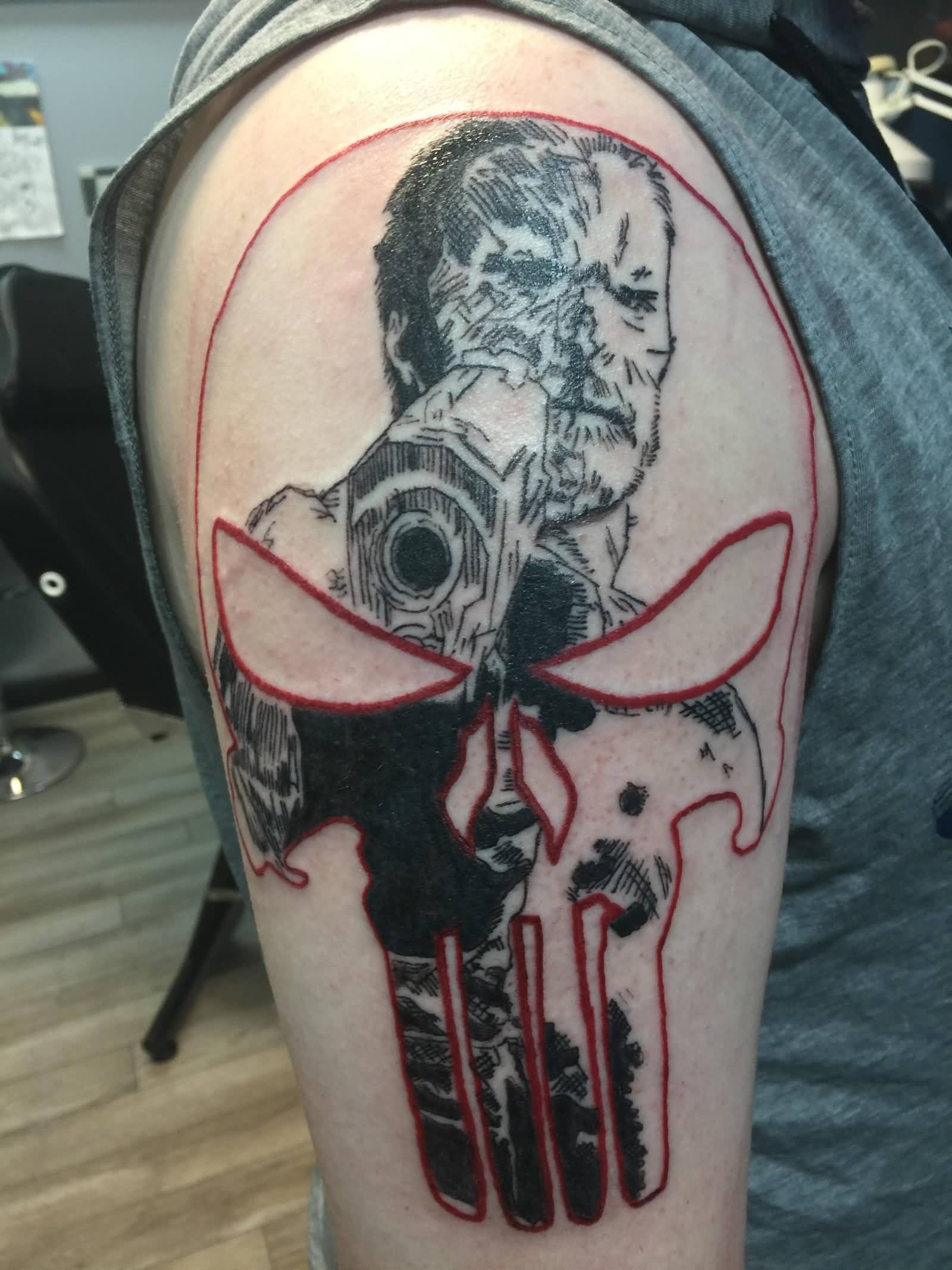 Black and red punisher skull and man tattoo on upper sleeve for men