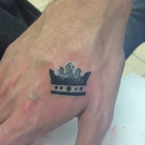 Black crown tattoo on upper hand
