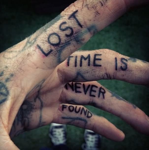 Black lost time is never found tattoo on side of fingers of left hand