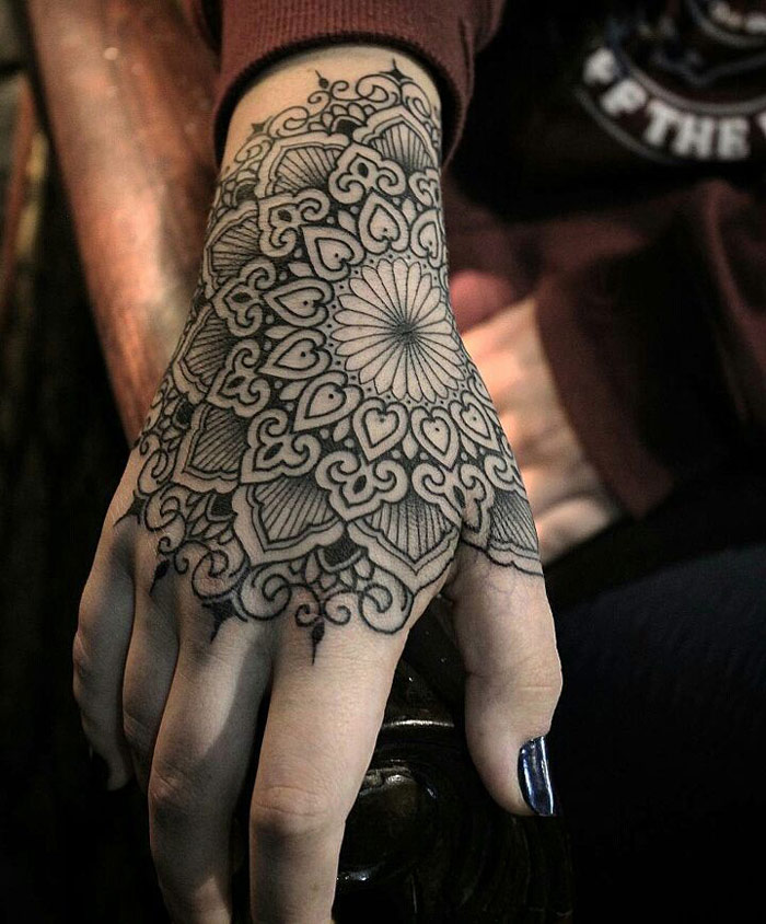 Black mandala tattoo design on upper hand for women