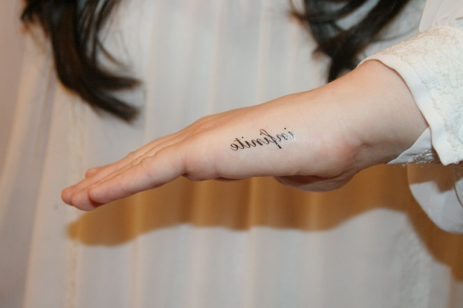 Black name tattoo on left hand