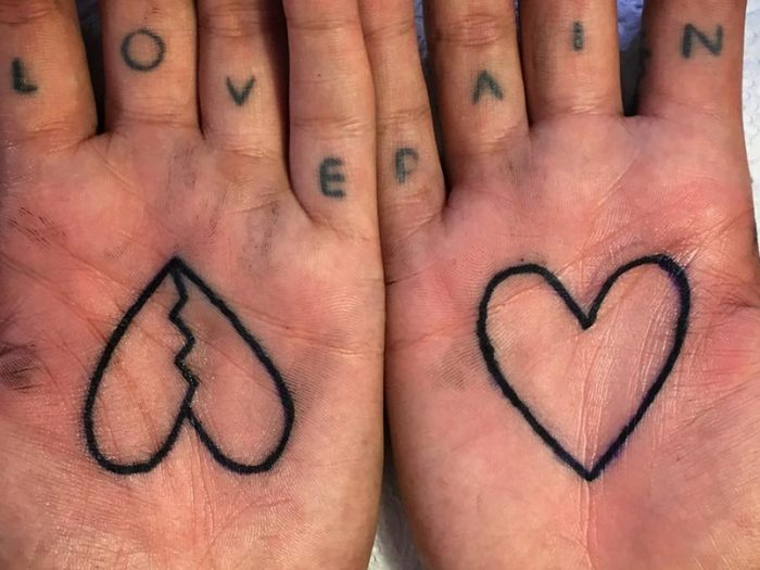 Black outlined heart tattoo on palm