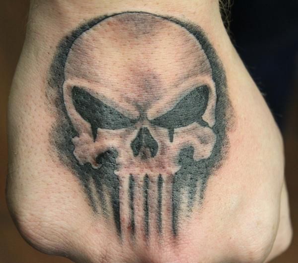 Black shaded punisher skull tattoo on upper hand