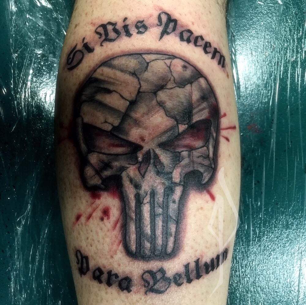 Black shaded punisher skull with text tattoo on body