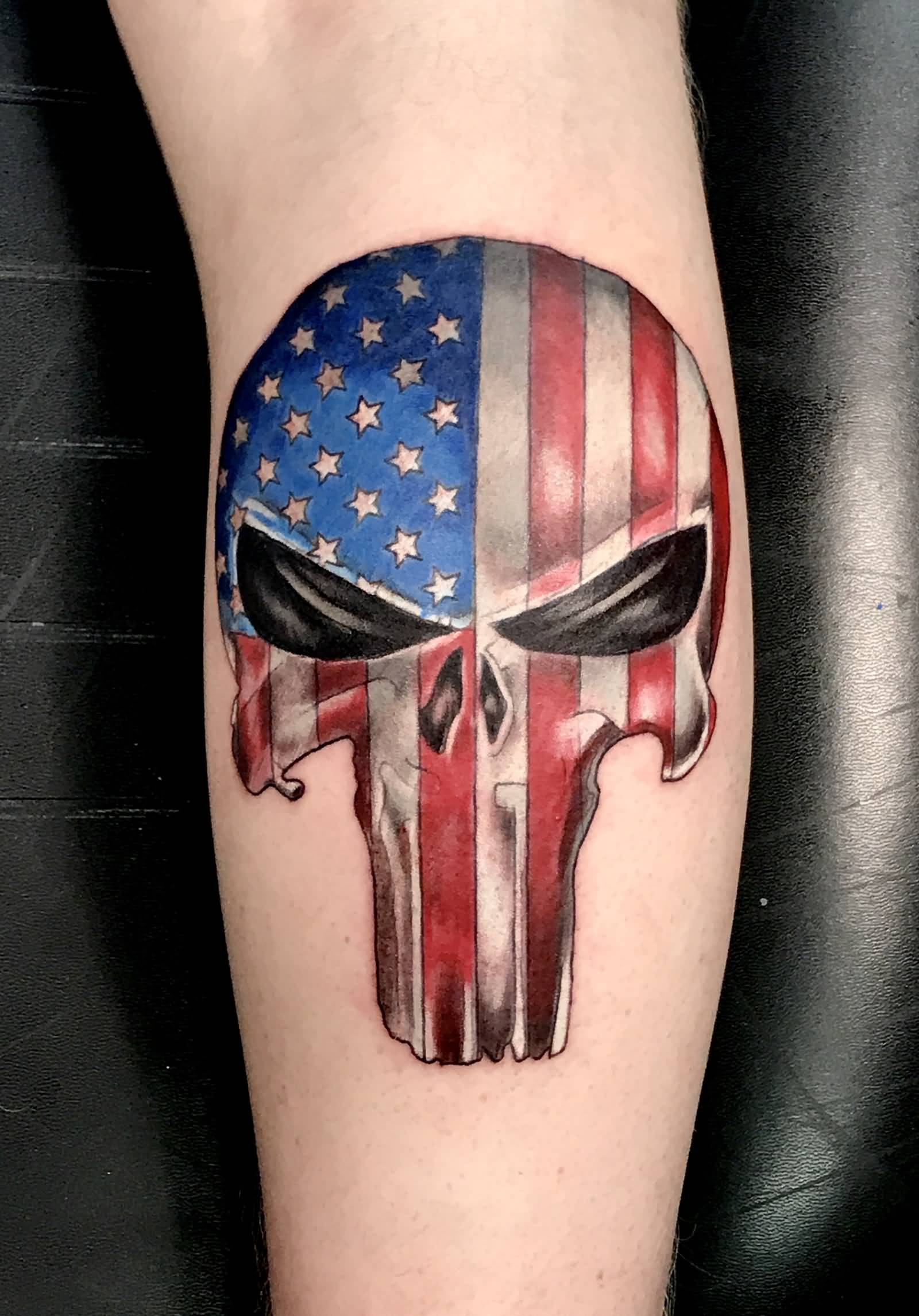 Colored American flag punisher tattoo on arm by Dan Bires.