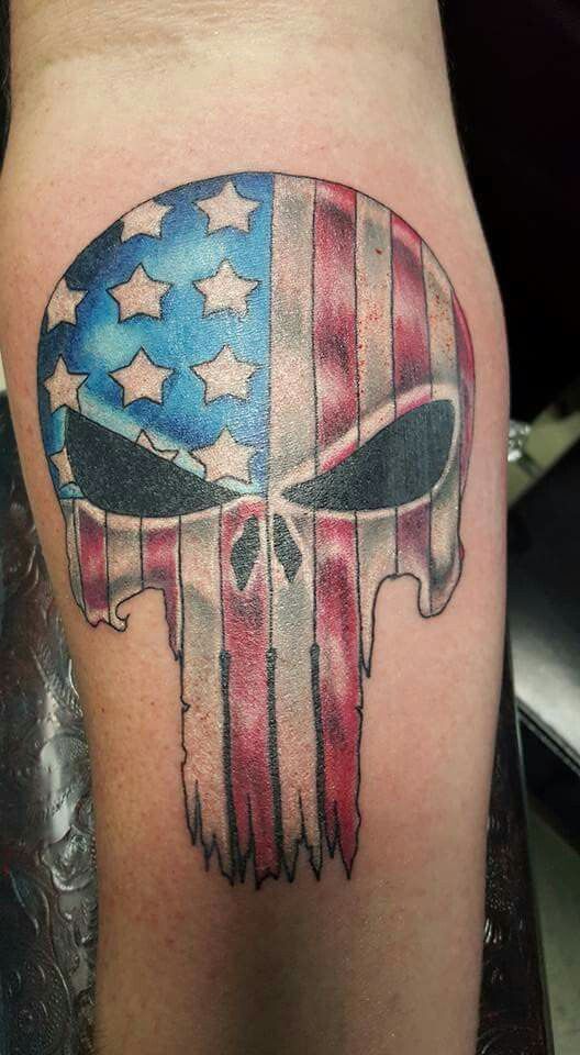 Colored American flag punisher tattoo on lower inner forearm