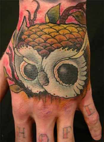 Colored owl pineapple tattoo on upper hand