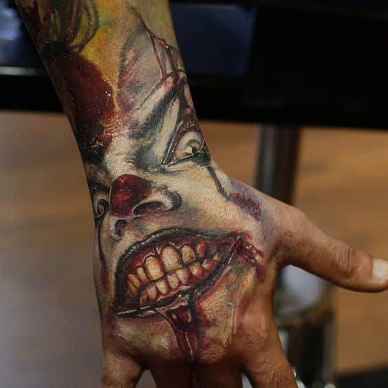 Colorful clown tattoo on upper hand