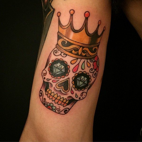 Colorful sugar skull with crown tattoo on body