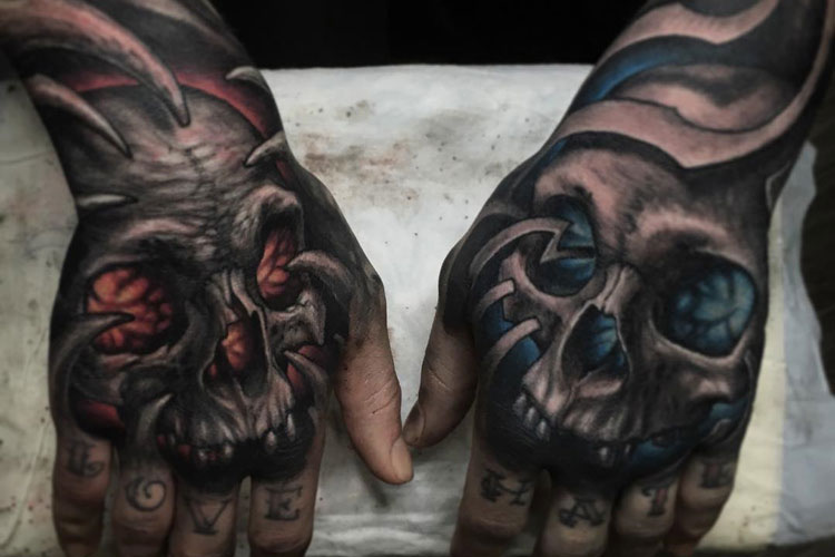 Grey shaded fire and water skull tattoo on upper hands