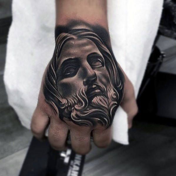 Grey shaded Jesus tattoo on upper right hand