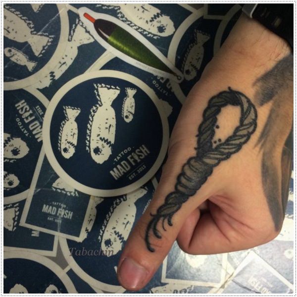 Grey shaded knot tattoo on left thumb