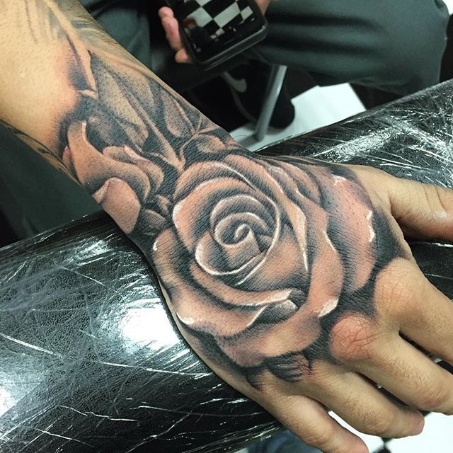 Grey shaded rose tattoo on upper right hand