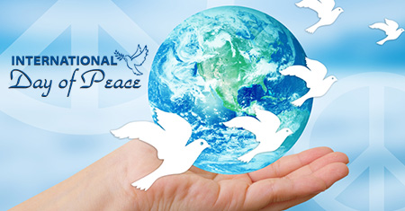 International Day of Peace earth globe and doves on hand